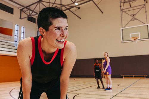 Female basketball player smiling during a practice session on an indoor court