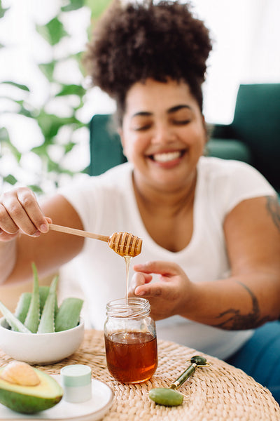 Healthy woman doing honey facial treatment