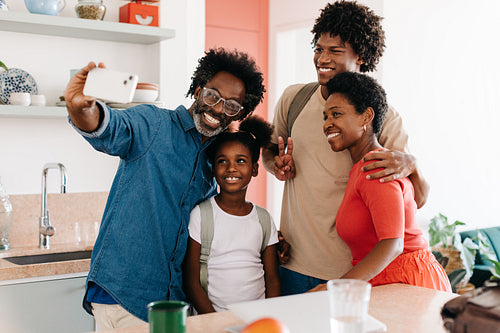 Father taking a selfie with his family in the morning at home
