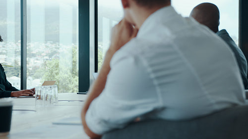 Businesswoman discussing work with team in boardroom