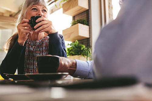 Senior woman at cafe with her husband