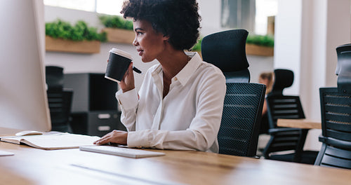 African businesswoman having coffee at her desk