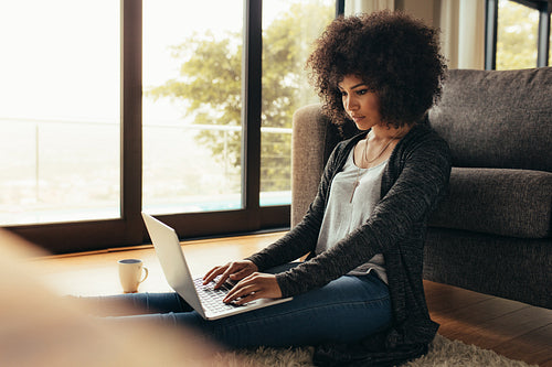 African female working on laptop computer at home