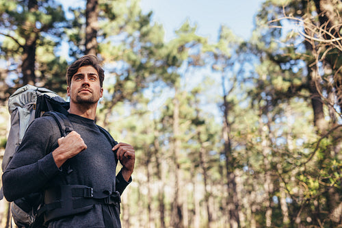 Man walking in forest wearing a backpack