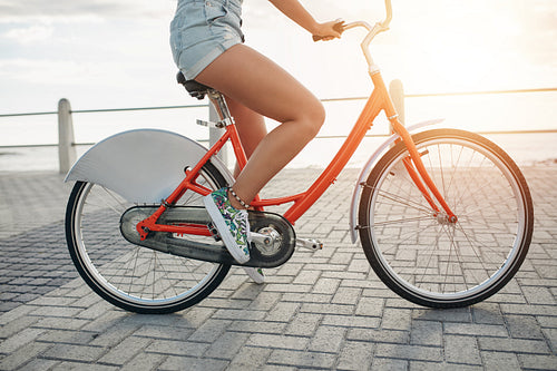 Young woman on her bike at the seaside road