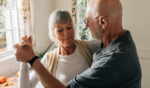 Elderly couple dancing at home