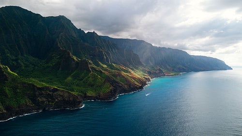 View of the rugged coastline along Na Pali Coast in Hawaii, with green mountains and blue sea waters