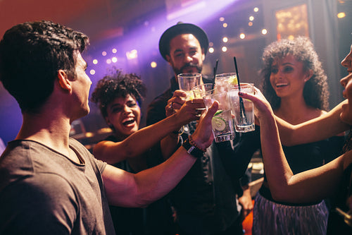  Group of friends at nightclub celebrating with drinks