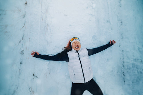 Tired woman rests in snow after vigorous winter run