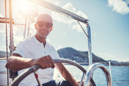 Confident senior man steering his boat