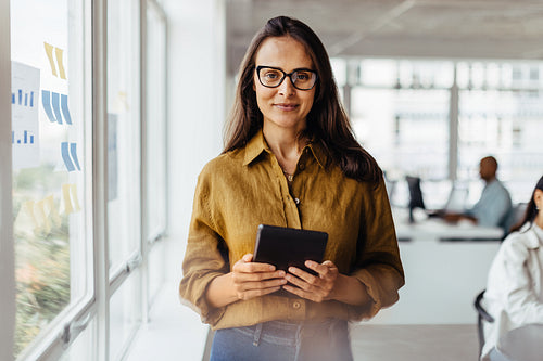 Sales executive holding a tablet in an office