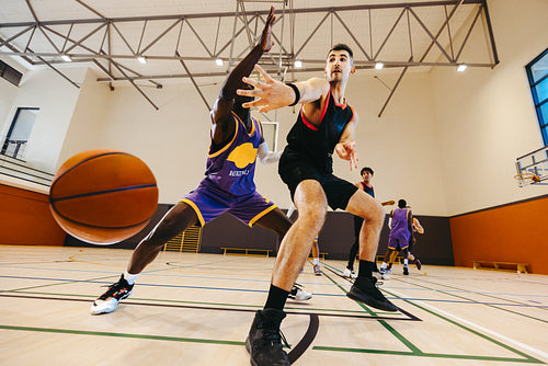 Two basketball players competing for possession during an indoor basketball game
