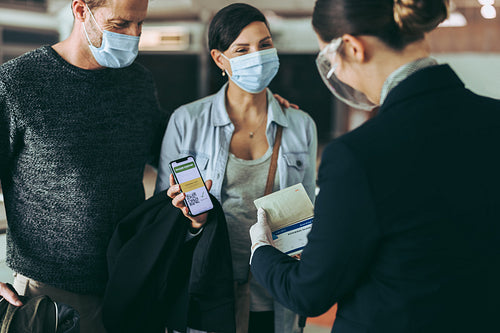 Couple displaying vaccine passport to airport staff