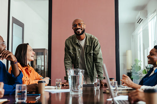 Happy business leader presenting strategy during a team meeting in a modern boardroom
