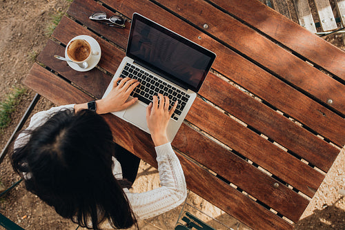 Young female working on her laptop at a cafe