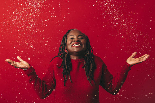 Joyful mature woman celebrating with confetti