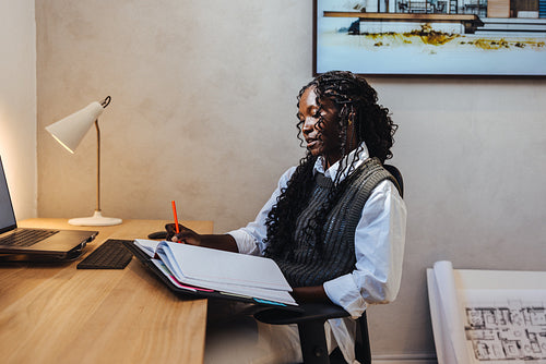 Female architect drafting and designing at desk in modern office setting