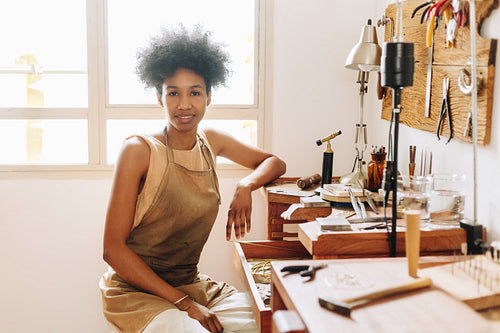 African artist at work desk in jewelry studio