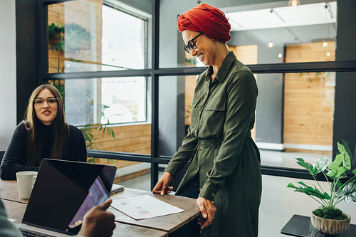 Cheerful Muslim businesswoman having a meeting with her team