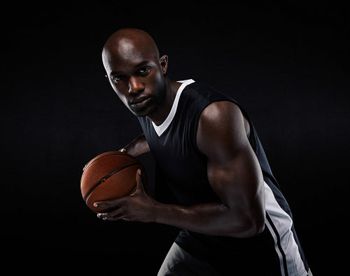 Fit young male athlete playing basketball