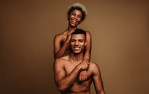 Happy african american couple together on brown background