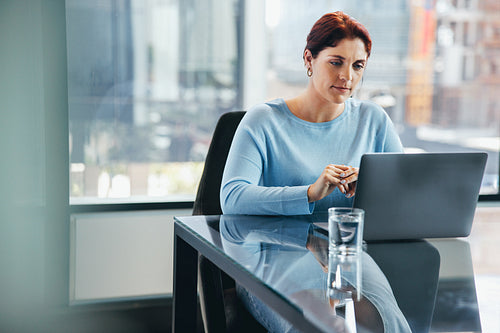 Business woman listens intently as she engages in a virtual meeting at work