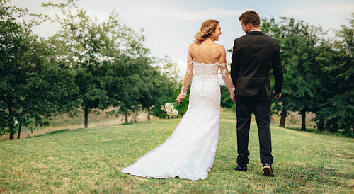 Newlywed couple walking together in park