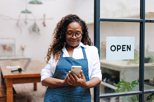 Female small business owner reading the online reviews for her flower shop