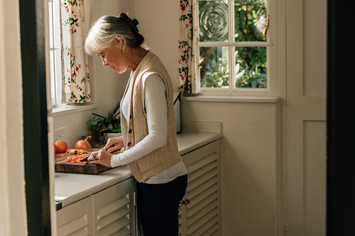 Senior woman preparing food in kitchen