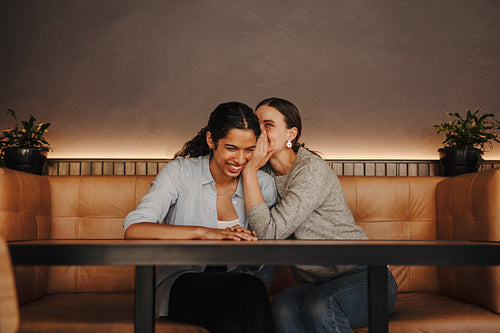 Two friends gossiping at the cafe