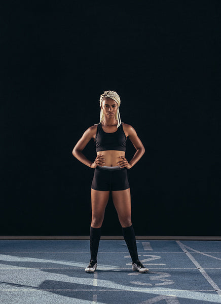Female sprinter standing on a running track