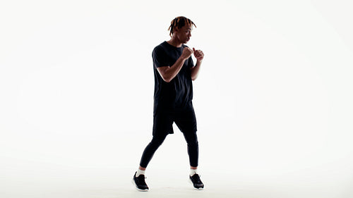 A focused athlete practices boxing techniques in a studio workout session