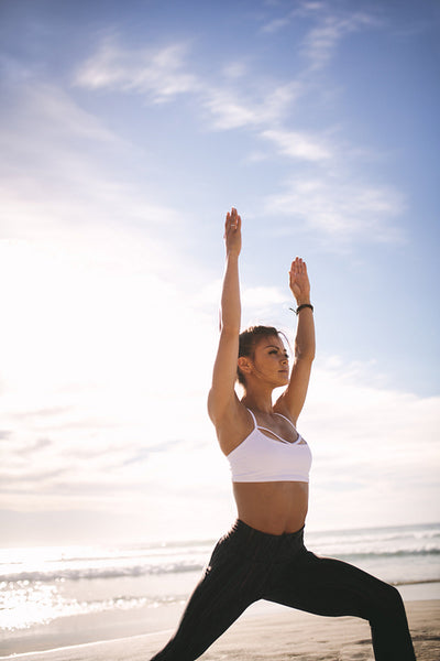 Woman practicing yoga at the beach