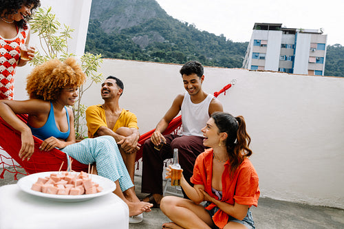 Group of friends on patio sharing conversation and laughter in Rio de Janeiro