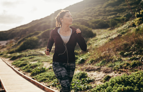 Woman running on path by the mountain
