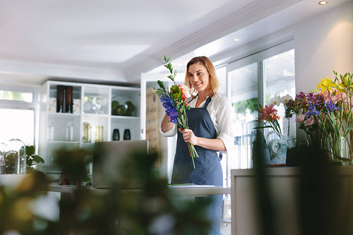 Female florist making bouquet at flower shop