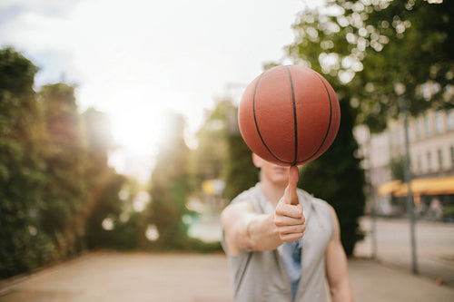 Man balancing basketball on his thumb
