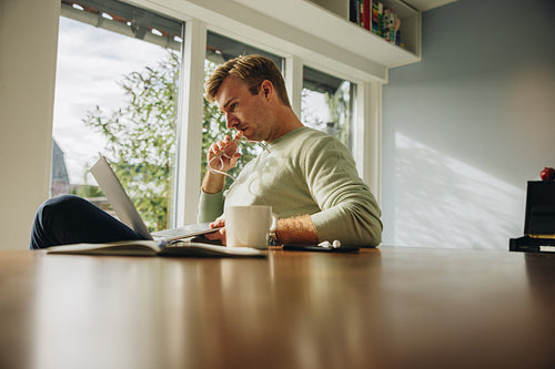 Man looking at his laptop and thinking