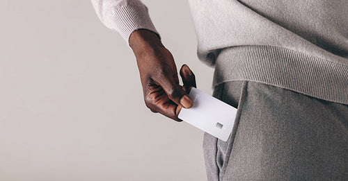 Professional man with a premium bank account puts his credit card into his pocket