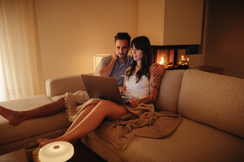 Young couple enjoying time together with a laptop in their living room