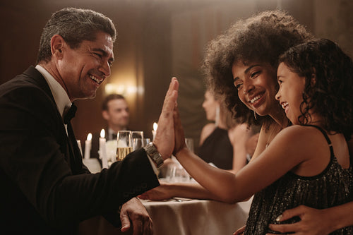 Mature man playing with a girl at dinner party