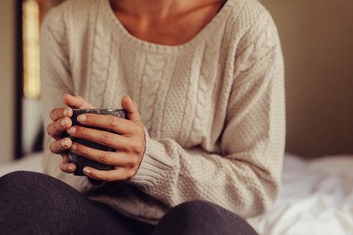 Woman having morning coffee in bed