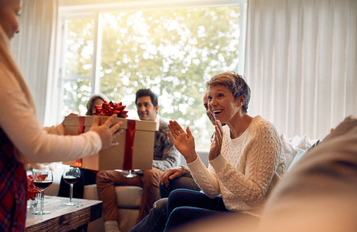 Little girl surprising her grandmother with a christmas present