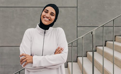 Happy Muslim sportswoman smiling at the camera outdoors