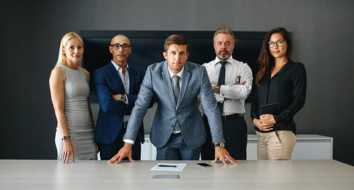 Business man standing with his corporate team in an office boardroom