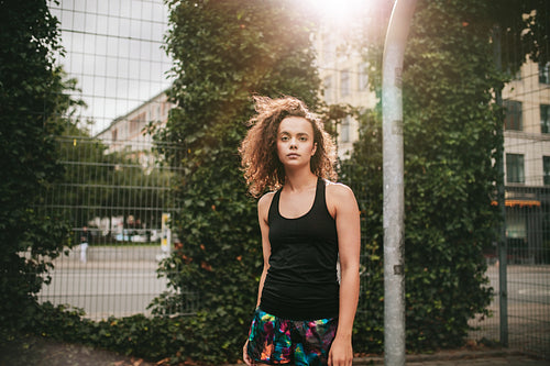 Beautiful young girl standing on basketball court