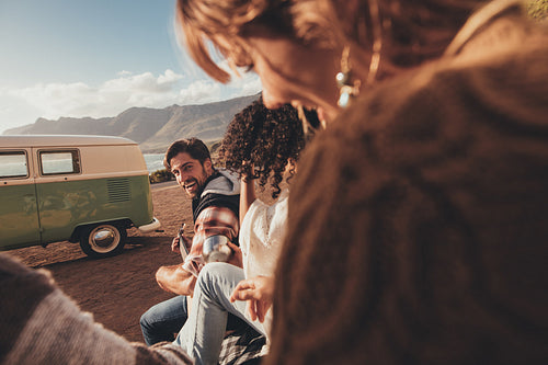 Man playing guitar for his friends on road trip
