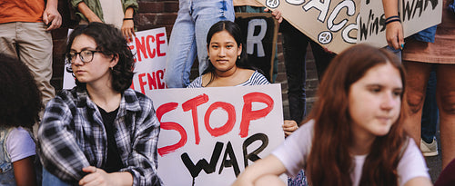 Young woman holding an anti-war banner during a protest