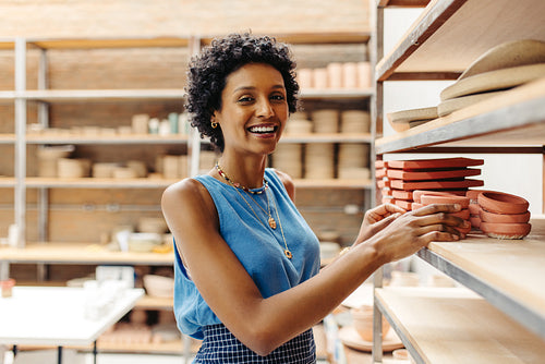 Ethnic female potter smiling at the camera in her shop