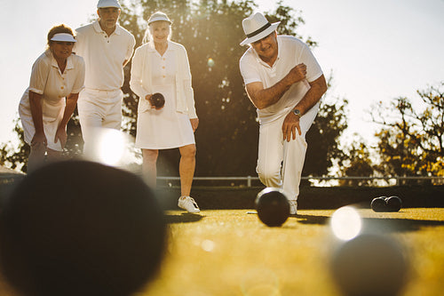 Senior people playing boules in a park